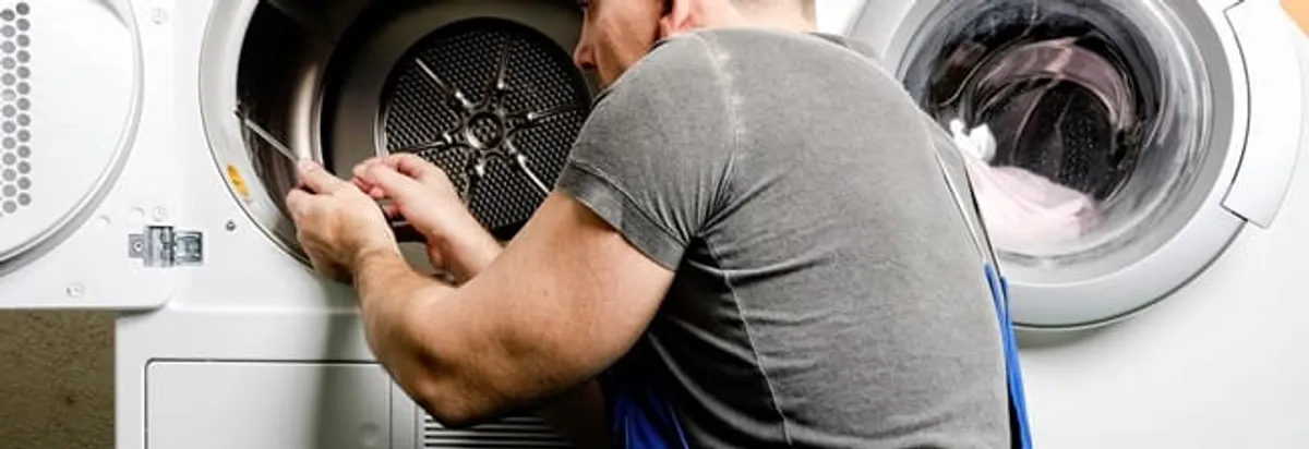 Dryer repair technician fixing a clothes dryer drum in Toledo, OH