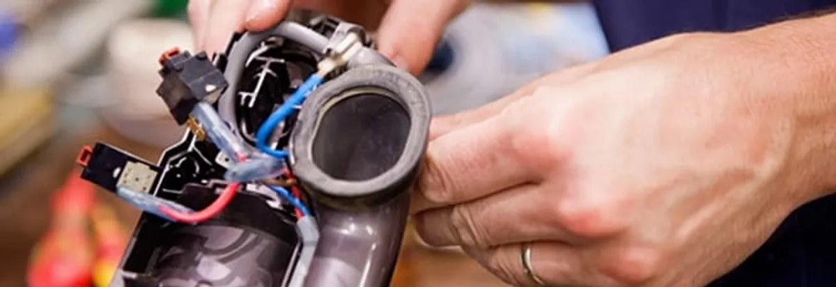 Vacuum repair technician reconnecting wiring and components in Toledo, OH